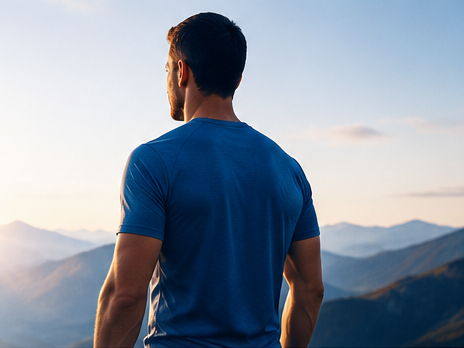 Man standing outdoors facing a mountain view